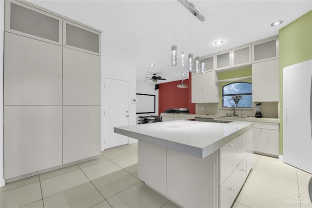 kitchen with white cabinetry, a center island, ceiling fan, and decorative light fixtures