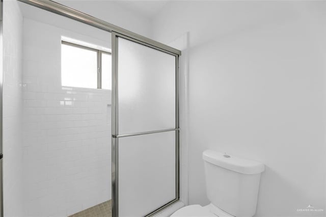 bathroom with toilet and a shower with shower door