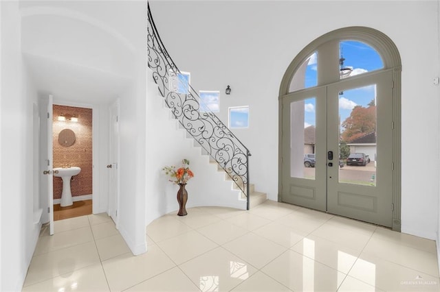 tiled entrance foyer with french doors and a high ceiling