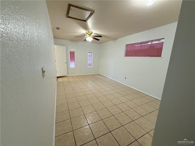 tiled spare room with ceiling fan