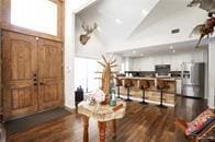 foyer featuring high vaulted ceiling and dark wood-type flooring