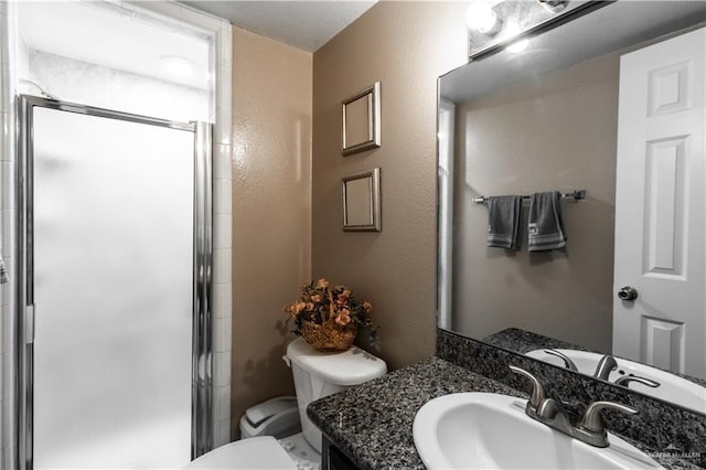 bathroom with vanity, toilet, and a shower with shower door