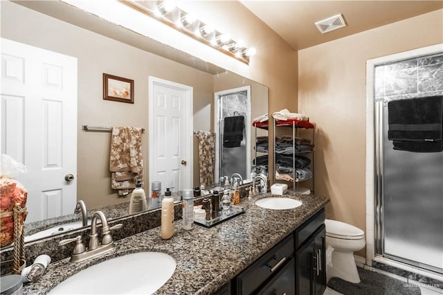 bathroom with vanity, toilet, and a shower with shower door