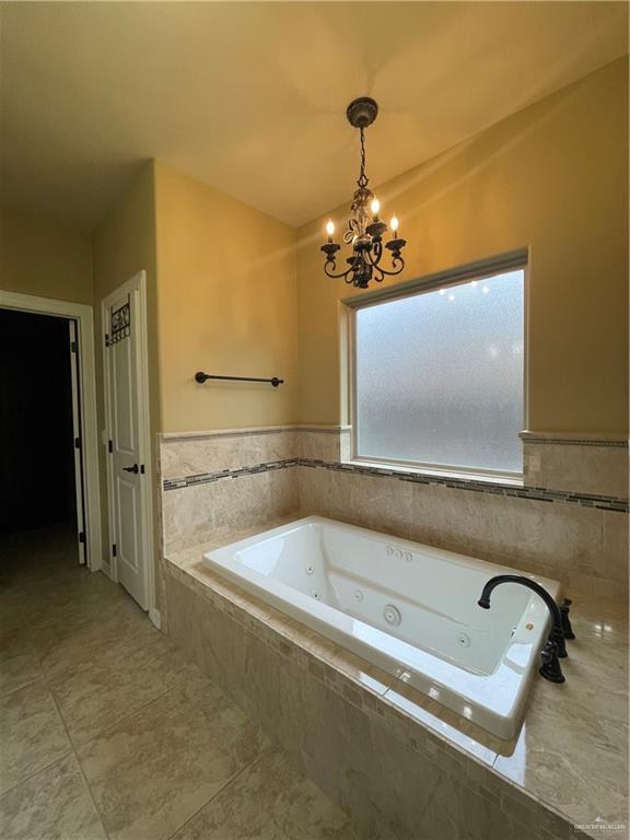 10210 N 28th Ln, Mcallen, TX 78504 - full bath featuring a chandelier, a tub with jets, and wainscoting