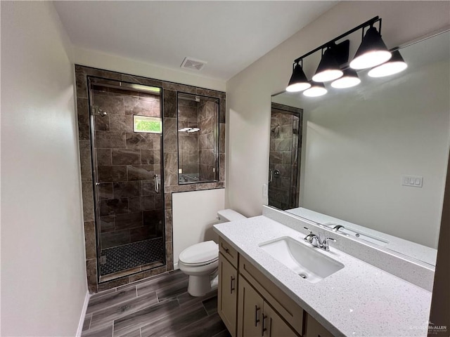 bathroom with vanity, an enclosed shower, and toilet