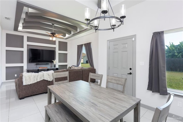 tiled dining space with ceiling fan with notable chandelier, built in features, and a wealth of natural light