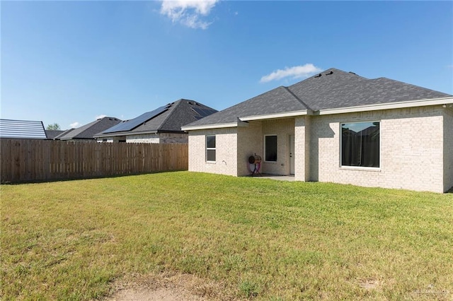 rear view of property featuring a lawn