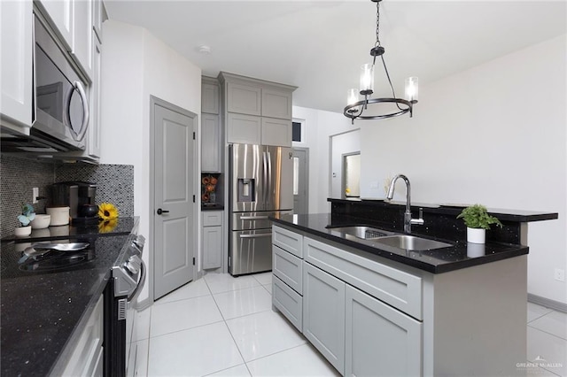 kitchen with sink, hanging light fixtures, decorative backsplash, light tile patterned floors, and stainless steel appliances