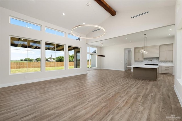 17956 Garrett Rd, Harlingen, TX 78552 - unfurnished living room with beam ceiling, light wood-style flooring, high vaulted ceiling, a chandelier, and recessed lighting