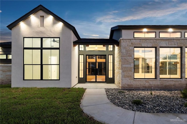 17956 Garrett Rd, Harlingen, TX 78552 - view of exterior entry featuring stone siding, stucco siding, and a yard
