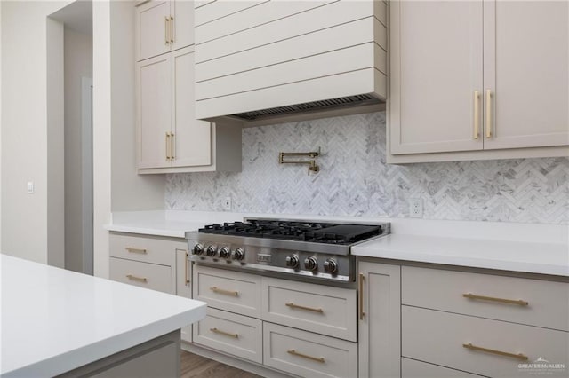 17956 Garrett Rd, Harlingen, TX 78552 - kitchen featuring stainless steel gas stovetop, premium range hood, light countertops, and tasteful backsplash