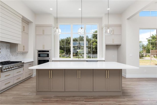 17956 Garrett Rd, Harlingen, TX 78552 - kitchen featuring appliances with stainless steel finishes, a center island, light countertops, decorative backsplash, and recessed lighting