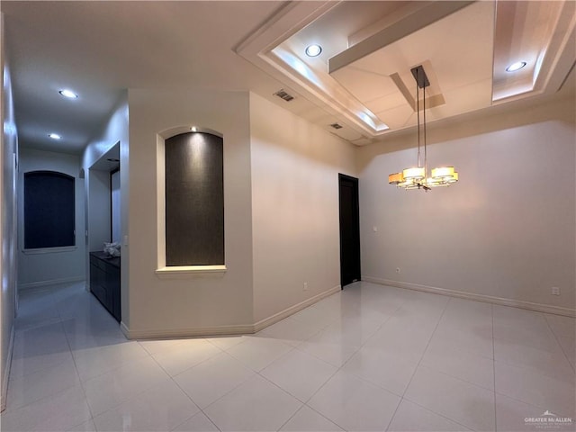 unfurnished room featuring a notable chandelier, light tile patterned floors, and a tray ceiling