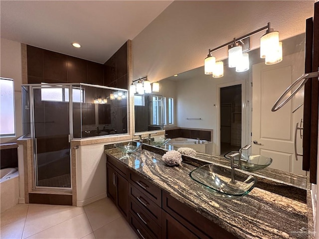 bathroom with tile patterned floors, vanity, and shower with separate bathtub