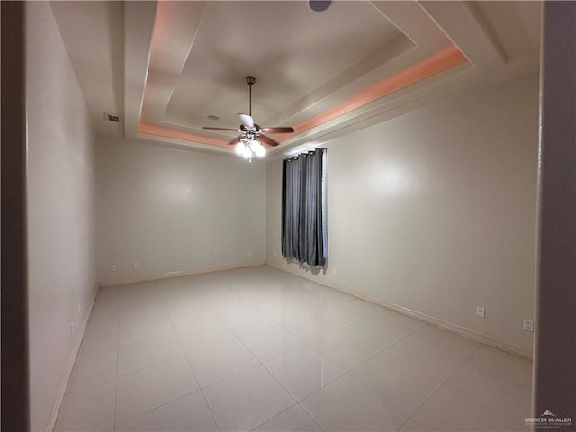 empty room featuring a raised ceiling and ceiling fan