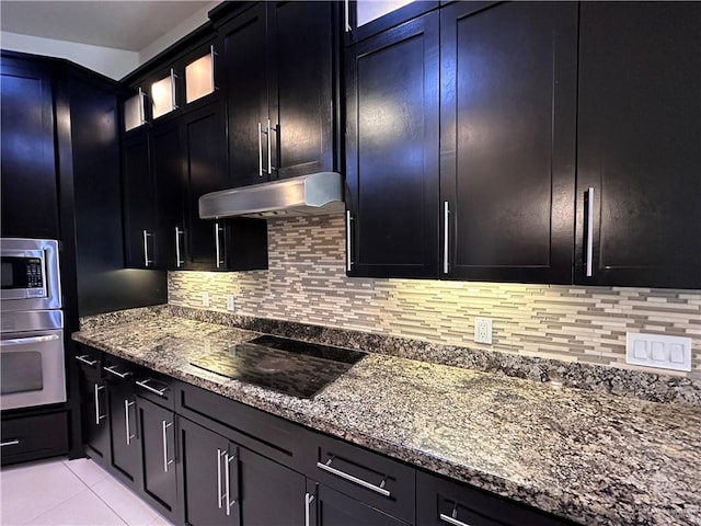 kitchen with tasteful backsplash, light tile patterned floors, stone countertops, and appliances with stainless steel finishes