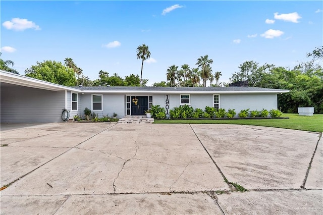 ranch-style home featuring a carport, driveway, and a front yard