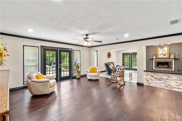 sitting room featuring wood finished floors, french doors, visible vents, and ornamental molding