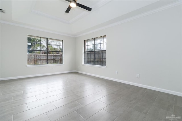 empty room featuring a tray ceiling, ceiling fan, and crown molding