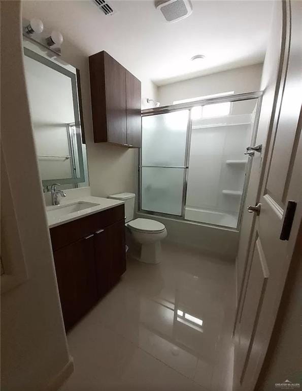 full bathroom with tile patterned floors, toilet, combined bath / shower with glass door, and vanity