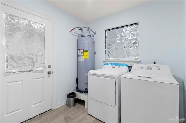 washroom featuring separate washer and dryer, electric water heater, and light hardwood / wood-style flooring