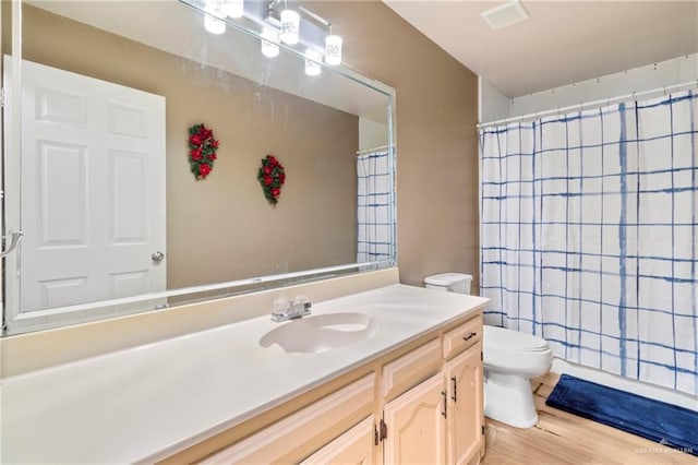 bathroom featuring toilet, vanity, a shower with shower curtain, and hardwood / wood-style flooring