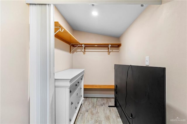 walk in closet featuring vaulted ceiling and light hardwood / wood-style flooring