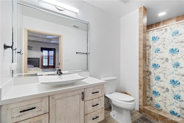 bathroom featuring walk in shower, vanity, and toilet