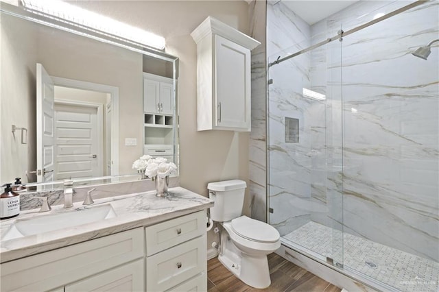 1518 Tierra Bella, Weslaco, TX 78596 - bathroom with a marble finish shower, toilet, vanity, and wood finished floors