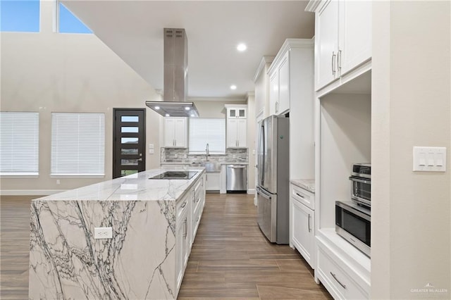 1518 Tierra Bella, Weslaco, TX 78596 - kitchen with appliances with stainless steel finishes, island exhaust hood, a kitchen island, decorative backsplash, and white cabinetry