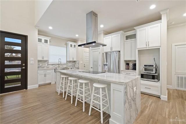 1518 Tierra Bella, Weslaco, TX 78596 - kitchen with stainless steel appliances, island exhaust hood, a sink, a kitchen island, and white cabinetry