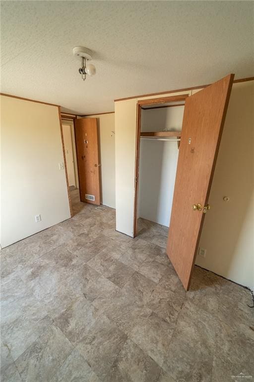 unfurnished bedroom with a textured ceiling and a closet