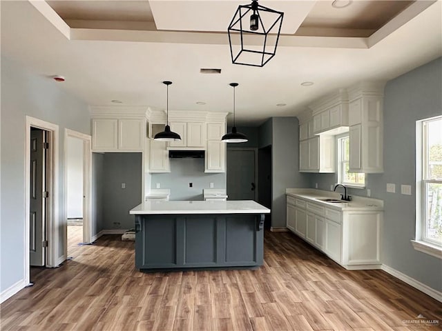 kitchen featuring sink, a kitchen island, pendant lighting, and hardwood / wood-style flooring