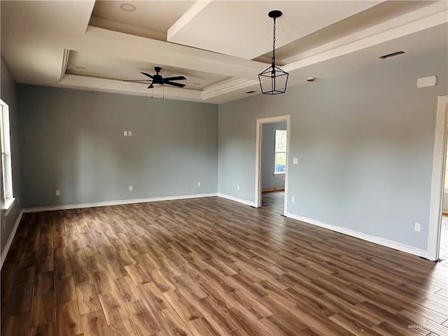 spare room featuring ceiling fan, a raised ceiling, and dark wood-type flooring