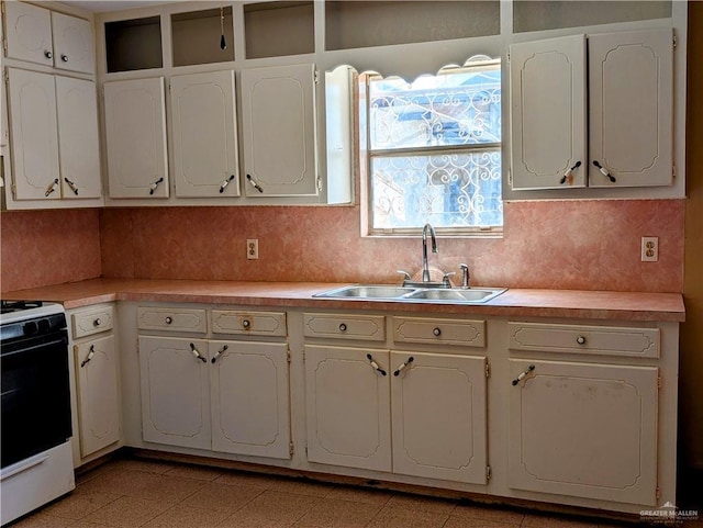 605 8th St, Hidalgo, TX 78557 - kitchen with white gas range, a sink, light countertops, and backsplash
