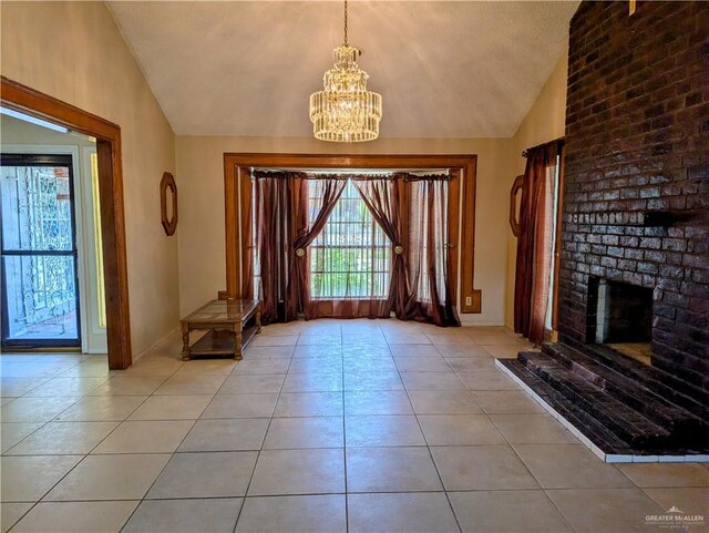 605 8th St, Hidalgo, TX 78557 - foyer with vaulted ceiling, a chandelier, light tile patterned floors, a fireplace, and baseboards
