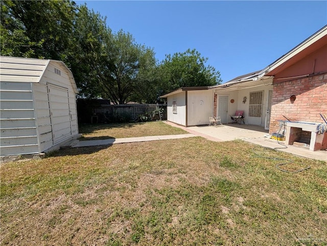 605 8th St, Hidalgo, TX 78557 - view of yard featuring a storage unit, a patio, and an outbuilding