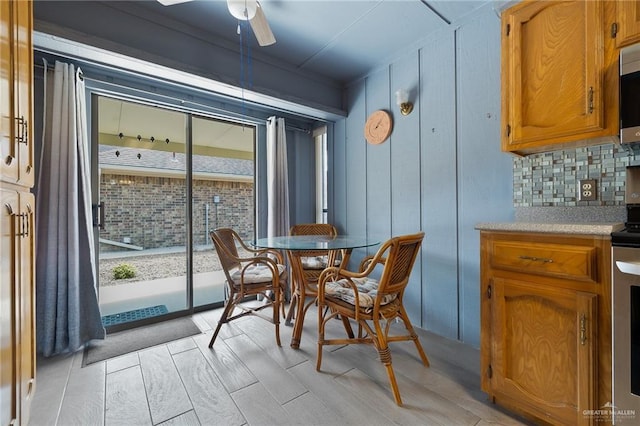 dining space with ceiling fan and light wood-type flooring