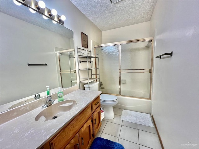 full bathroom with tile patterned floors, toilet, combined bath / shower with glass door, a textured ceiling, and vanity