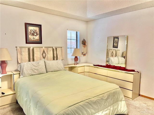 bedroom with light colored carpet and a textured ceiling