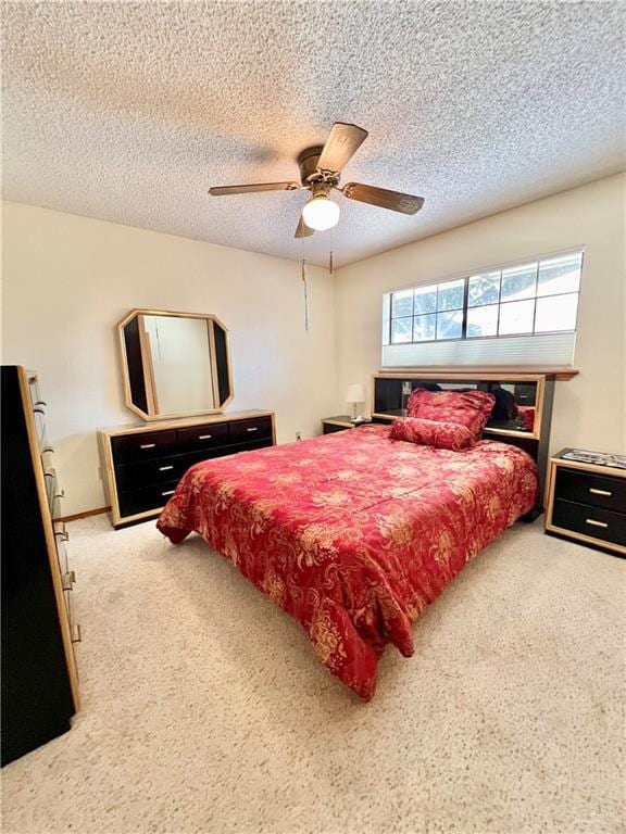 bedroom featuring ceiling fan, carpet floors, and a textured ceiling