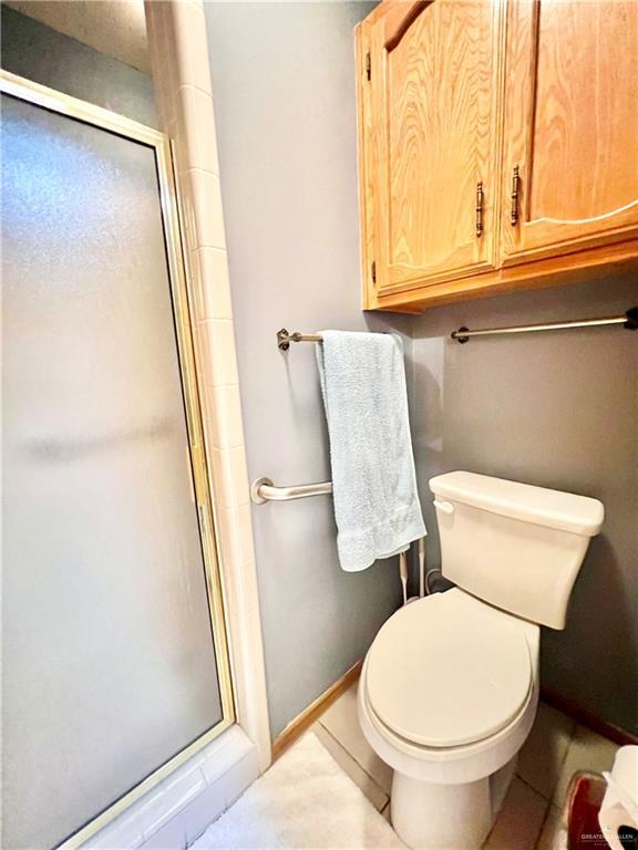 bathroom with toilet and a shower with shower door