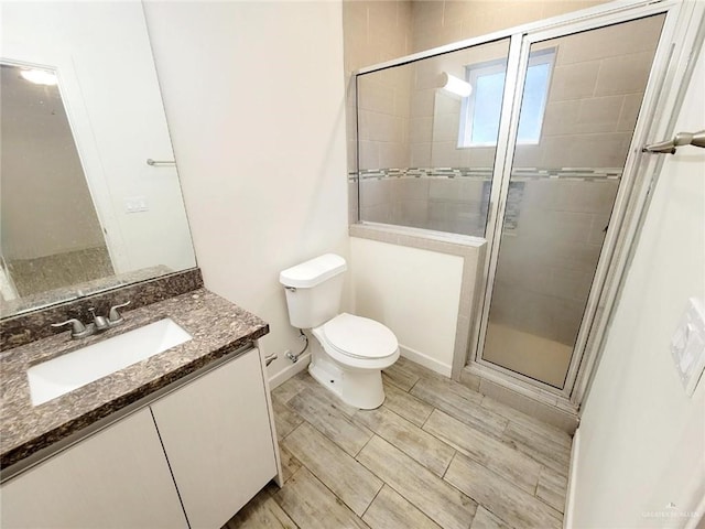 bathroom featuring vanity, toilet, and walk in shower