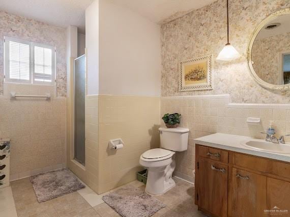 131 N Missouri Ave, Mercedes, TX 78570 - full bathroom with vanity, toilet, tile walls, and a stall shower