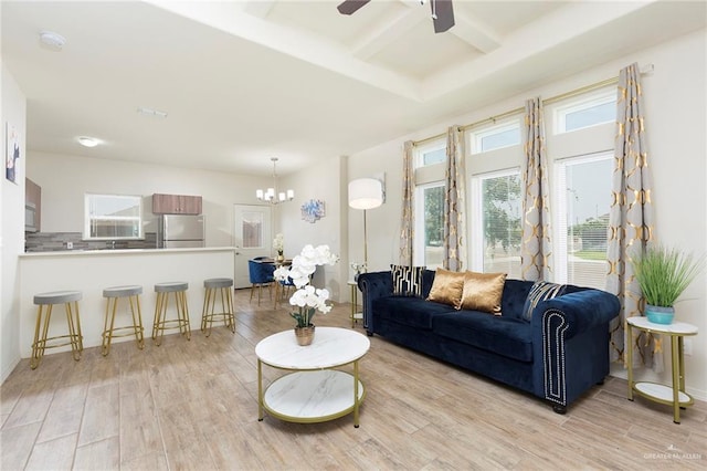 living room featuring ceiling fan with notable chandelier and light hardwood / wood-style floors