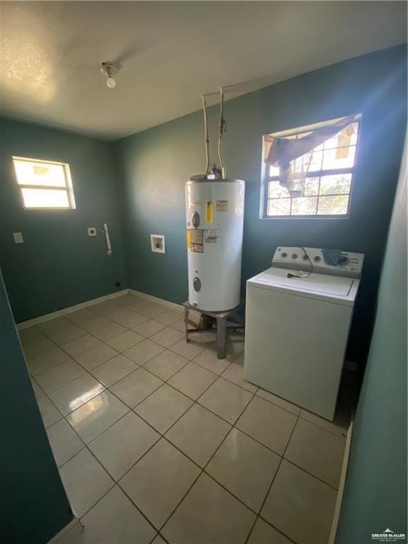 laundry area featuring water heater, light tile patterned floors, and washer / dryer