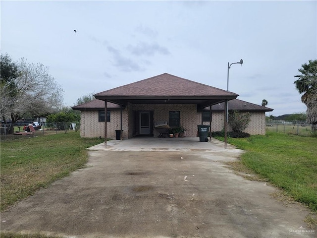 view of front of home with a carport and a front lawn