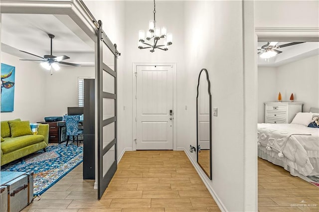 16593 W Mccullar Ct, Harlingen, TX 78552 - entrance foyer featuring ceiling fan, a barn door, light wood-style floors, and a chandelier