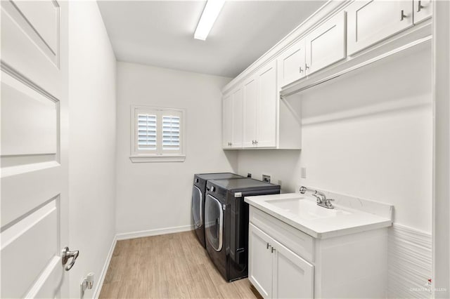 16593 W Mccullar Ct, Harlingen, TX 78552 - washroom featuring cabinet space, separate washer and dryer, light wood-style floors, and baseboards