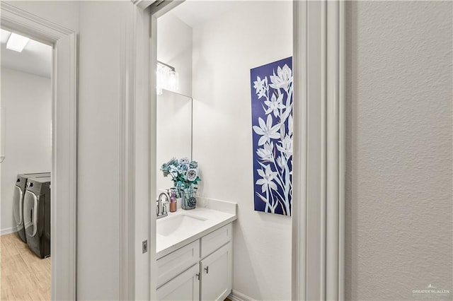 16593 W Mccullar Ct, Harlingen, TX 78552 - bathroom featuring washer and clothes dryer, vanity, and wood finished floors